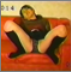 An attractive Asian girl farts while sitting on a sofa.